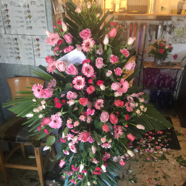 Large pink floral standing spray with roses, gerbera daisies, and tulips