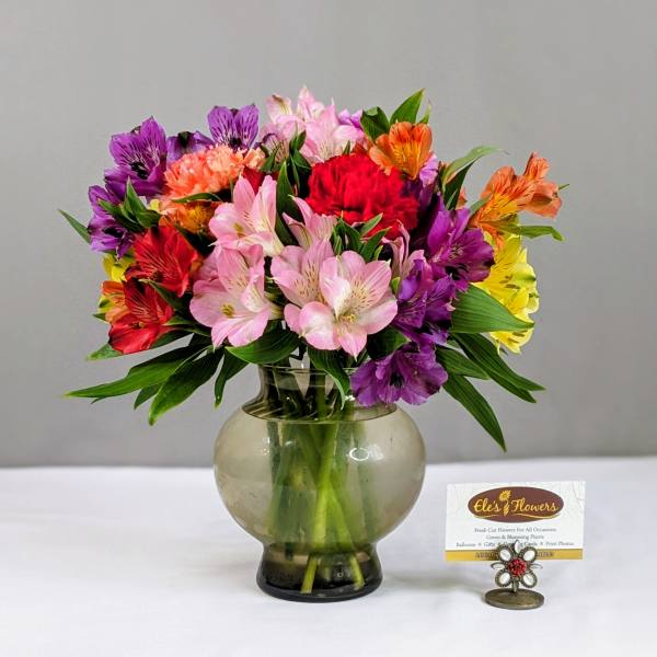 Colorful mixed bouquet in a round glass vase