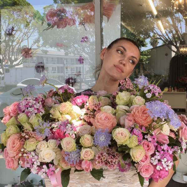 Large basket arrangement of pink and cream roses with lavender flowers