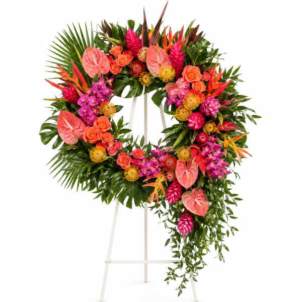 Heart-shaped floral wreath on a stand with pink, orange, and green tropical blooms