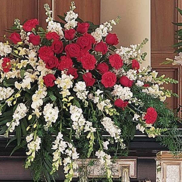 Large funeral spray of red roses and white flowers