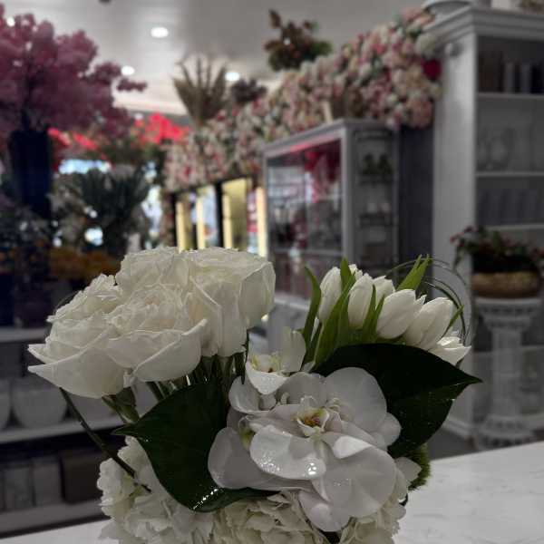 White floral arrangement in a clear square vase