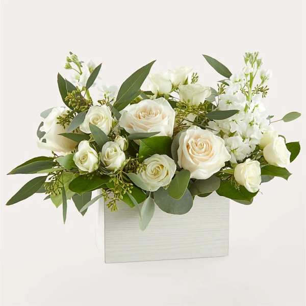 White roses and white blooms arranged in a white rectangular box