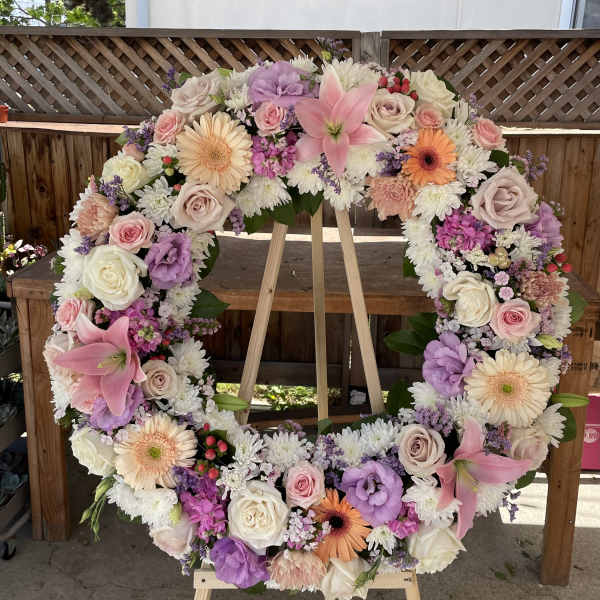 Large floral wreath with pink, white, and lavender blooms on an easel