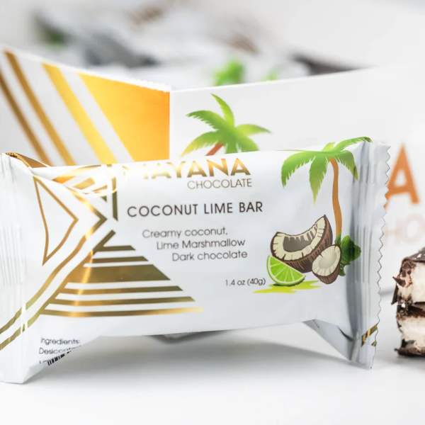 Wrapped coconut lime chocolate bar with a bitten piece beside it