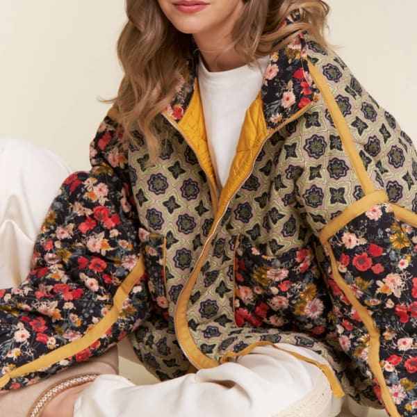Woman wearing a patterned floral quilted jacket over a white top