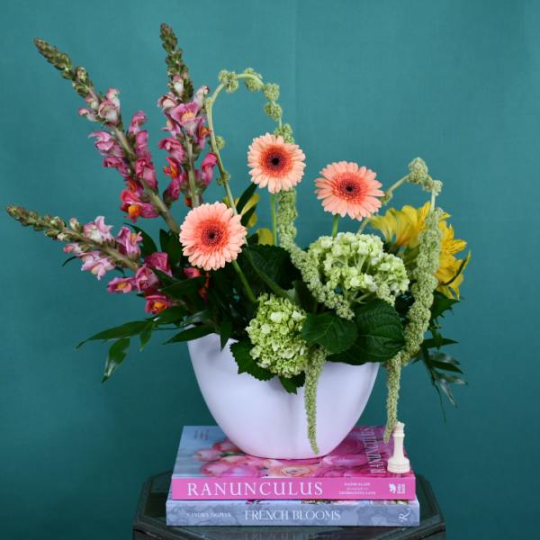 Mixed bouquet in a white vase with pink gerberas and green hydrangeas