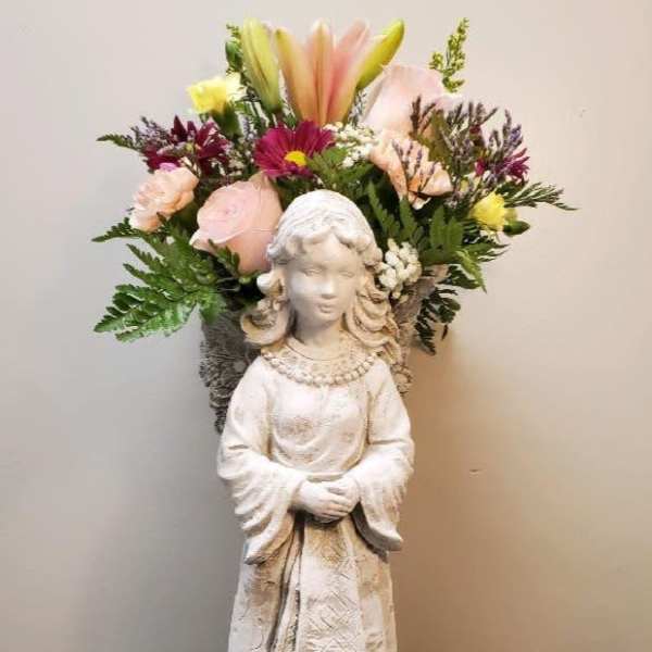 Flower arrangement in a statue vase with pink, yellow, and purple blooms