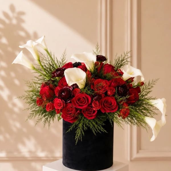 Red roses and white calla lilies in a black vase