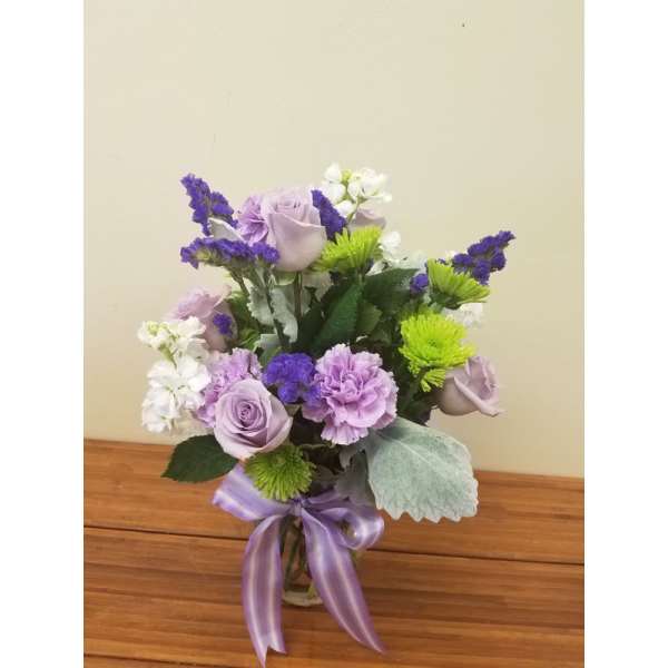 Lavender and white bouquet with purple accents in a glass vase