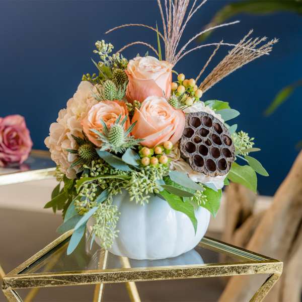 Peach roses and cream hydrangea in a white vase with dried accents