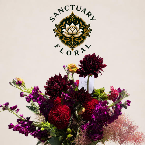 Purple and red floral arrangement in a gold vase