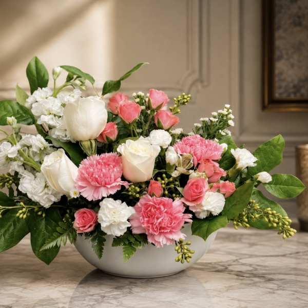 Pink and white mixed flower arrangement in a low white bowl