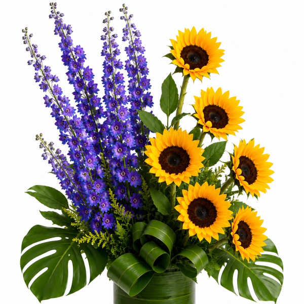 Sunflowers and purple delphinium in a clear glass vase