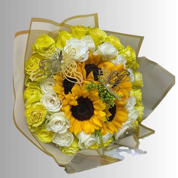 Bouquet of yellow and white roses with sunflowers wrapped in translucent paper
