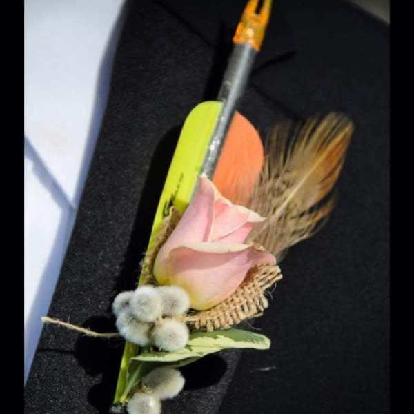 Pink rose boutonniere with dried grasses and a pencil