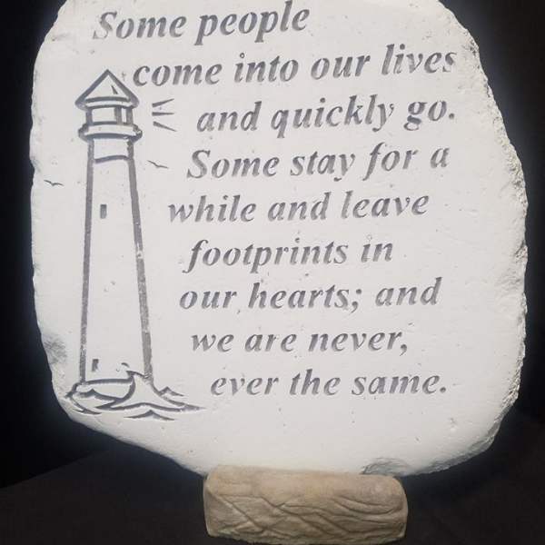 Decorative stone plaque with a lighthouse and memorial quote