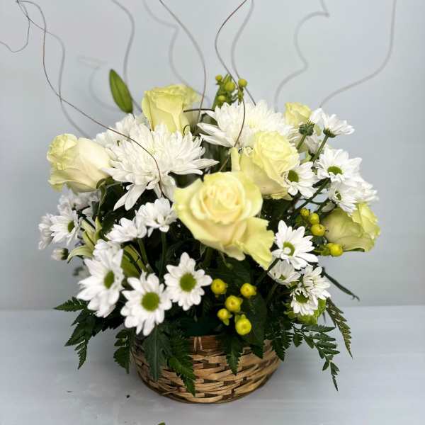 Basket arrangement of pale yellow roses and white daisies