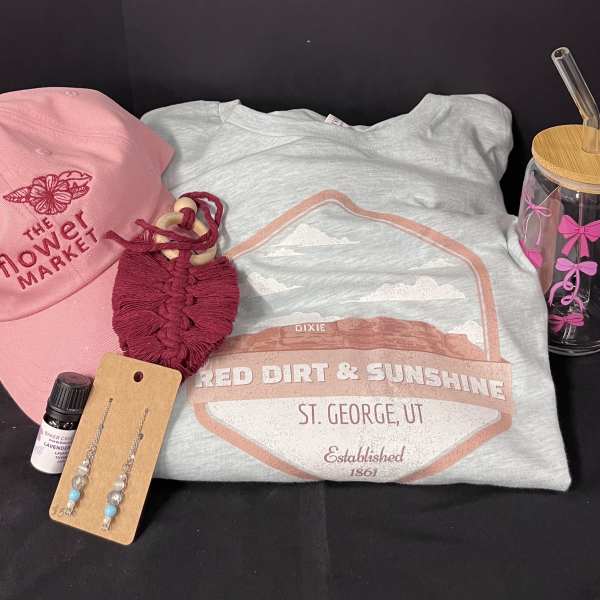 Gift set with a pink cap, T-shirt, tumbler, earrings, and a small bottle