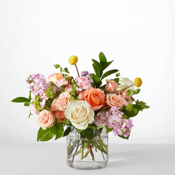 Mixed pink and peach roses in a clear glass vase
