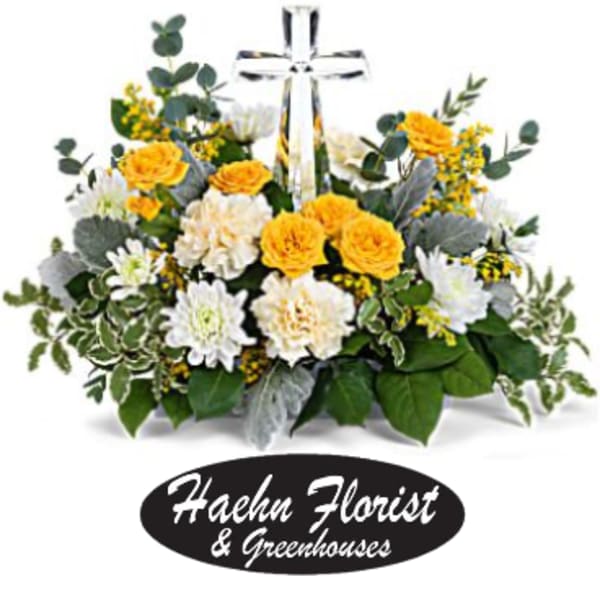 Yellow and white flower arrangement with a clear cross centerpiece