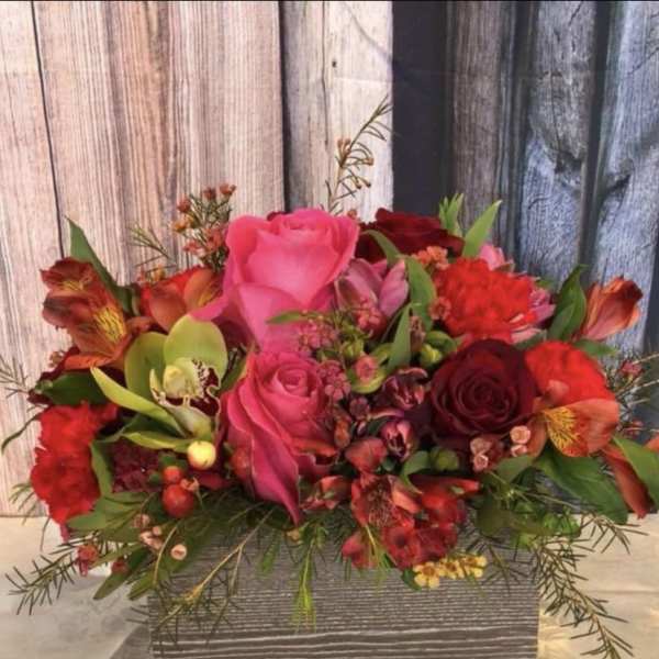 Mixed bouquet of pink and red flowers in a rectangular box