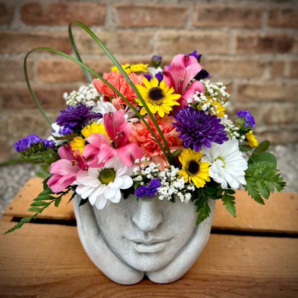 Colorful mixed bouquet in a gray face-shaped planter