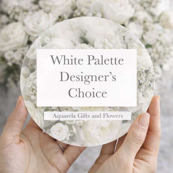 Hands holding a round card over a white flower arrangement