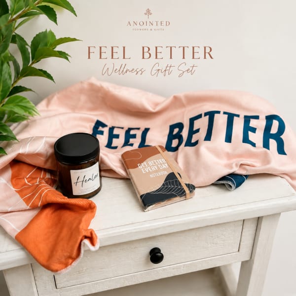 Wellness gift set with a scarf, candle jar, and notebook on a white table