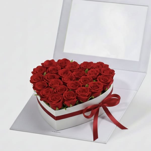 Heart-shaped box filled with red roses and tied with a red ribbon
