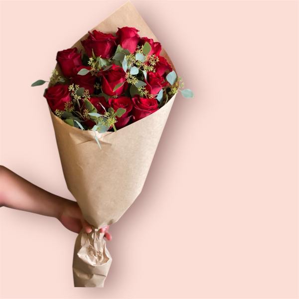 Bouquet of red roses wrapped in brown paper