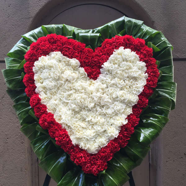 White heart on red heart Carnations with Ti leaves surround wreath - F30009