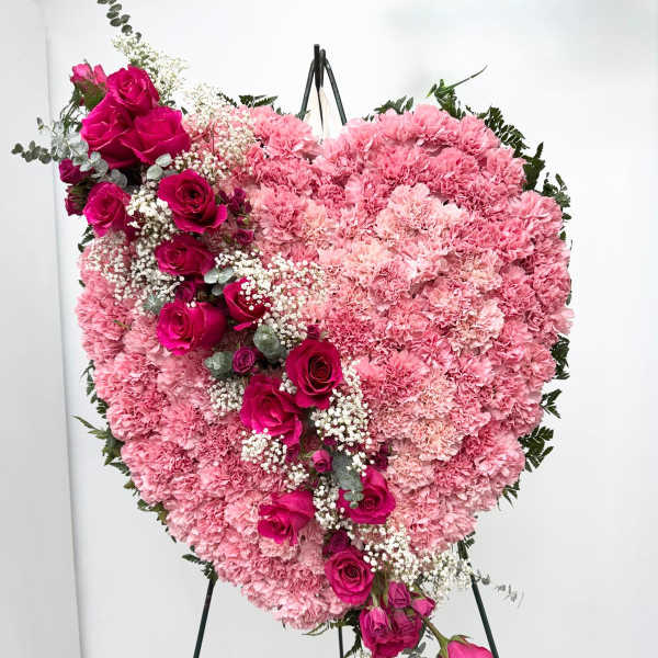 Heart-shaped pink floral standing arrangement with roses and carnations