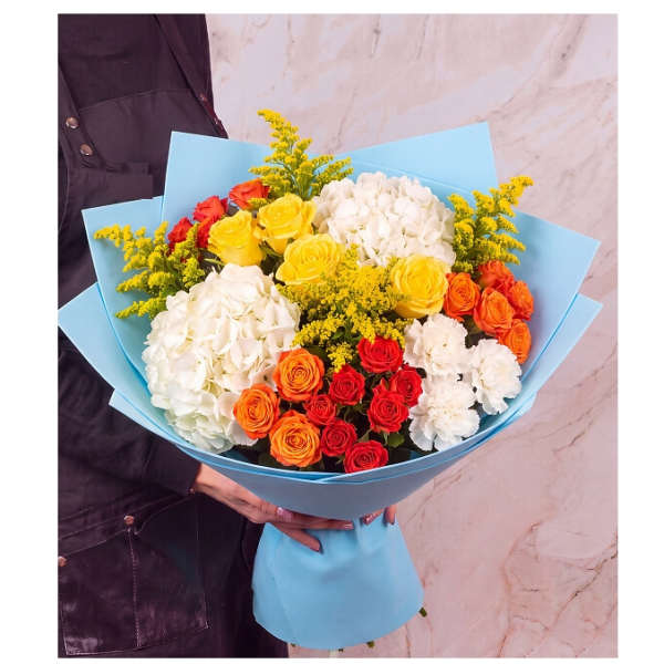 Bouquet of roses, hydrangeas, and yellow filler flowers wrapped in blue paper