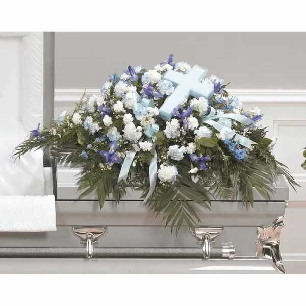 White and blue funeral casket spray with ribbon and cross