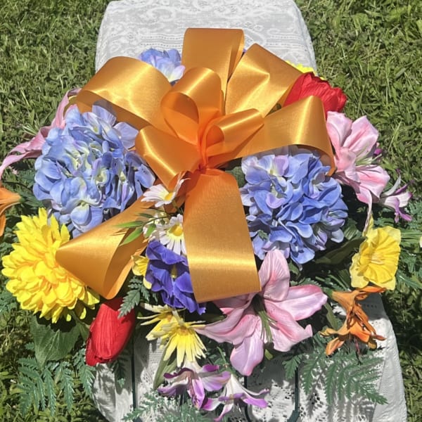 Colorful flower arrangement with a large gold ribbon bow