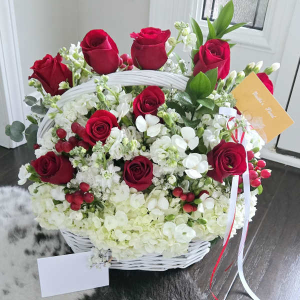 White basket arrangement with red roses and white hydrangeas