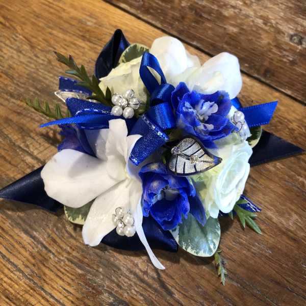 Blue and white floral corsage with ribbon and pearl accents