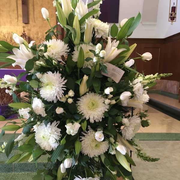 Large white floral standing spray with lilies and chrysanthemums