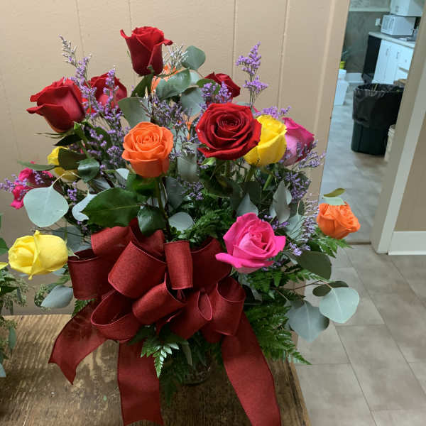 Mixed roses in a vase with a large red ribbon bow