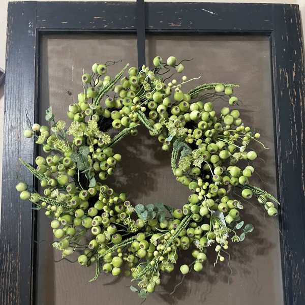 Green berry wreath on a dark framed background