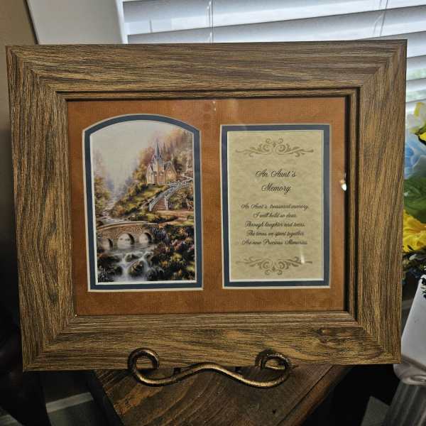 Wooden memorial frame with a printed tribute and landscape scene