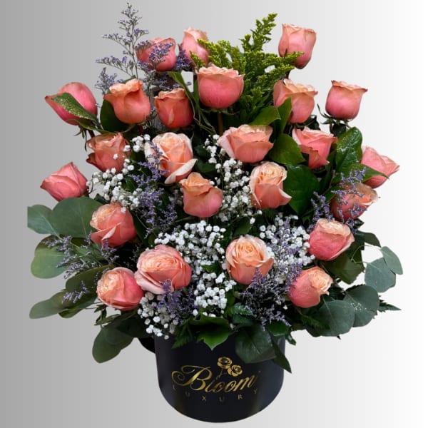 Pink roses arranged in a black vase with white filler flowers