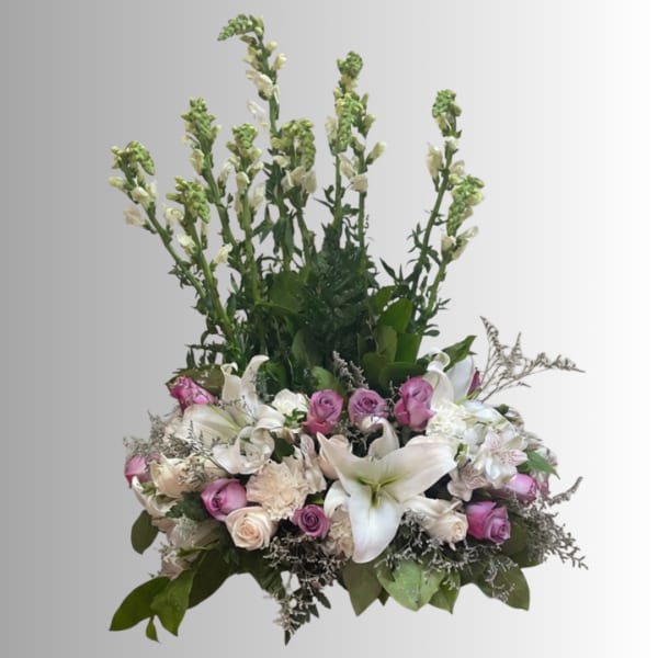 Tall floral arrangement with white lilies and pink roses in a low base
