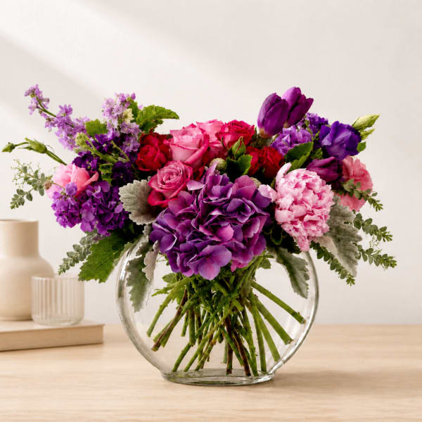 Purple and pink mixed bouquet in a clear glass vase