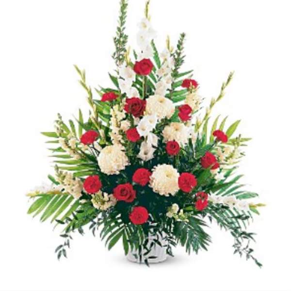 Tall floral arrangement with red and white flowers in a white container