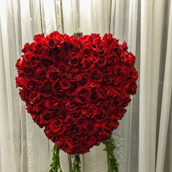 Heart-shaped red rose arrangement with hanging greenery