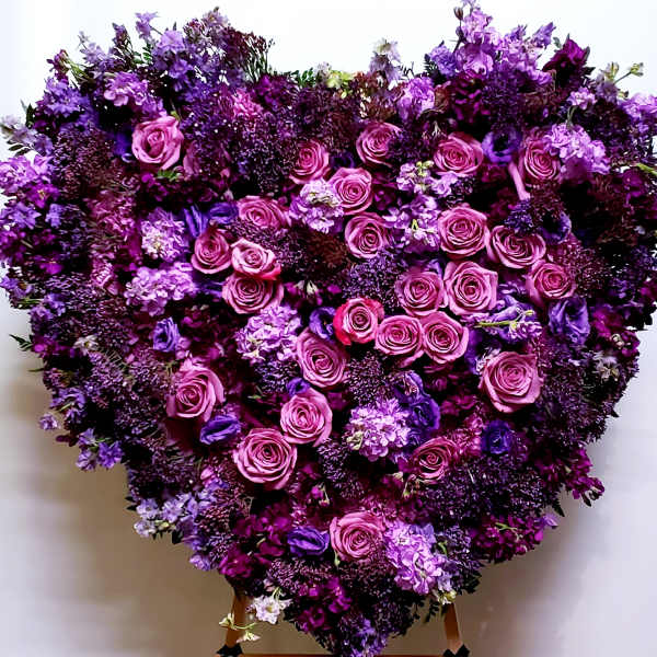 Heart-shaped floral arrangement of pink and purple roses