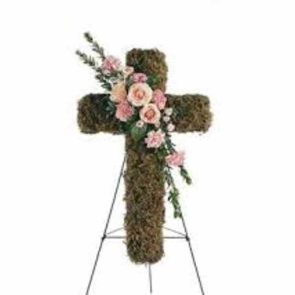 Floral cross on an easel with pink roses and greenery