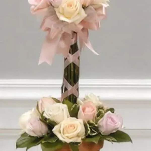 Two-tier rose arrangement in a terracotta pot with pink ribbon
